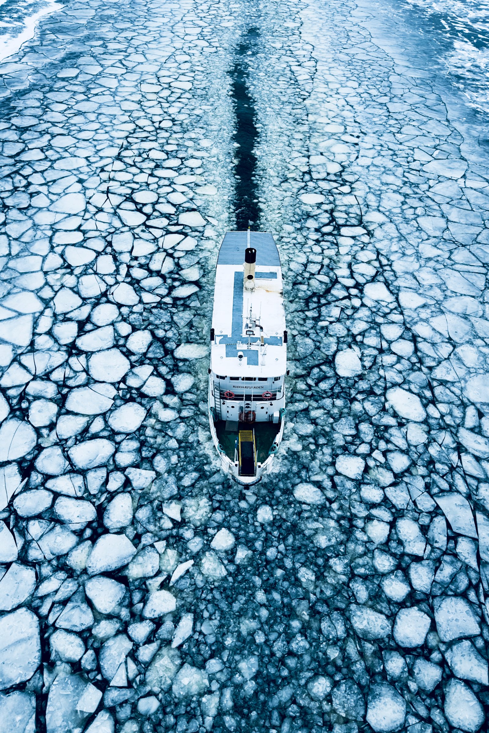 Aerial of a boat cutting through drift ice