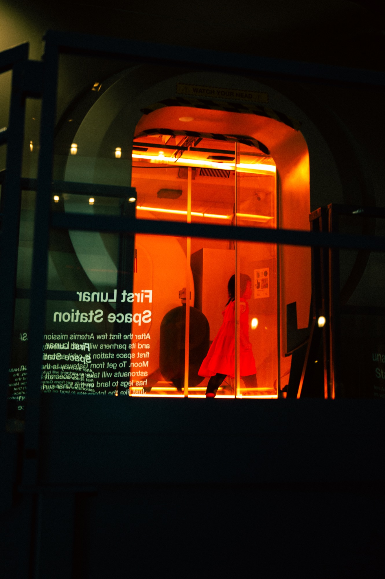 A figure in red crosses the glowing mock-up of the First Lunar Space Station