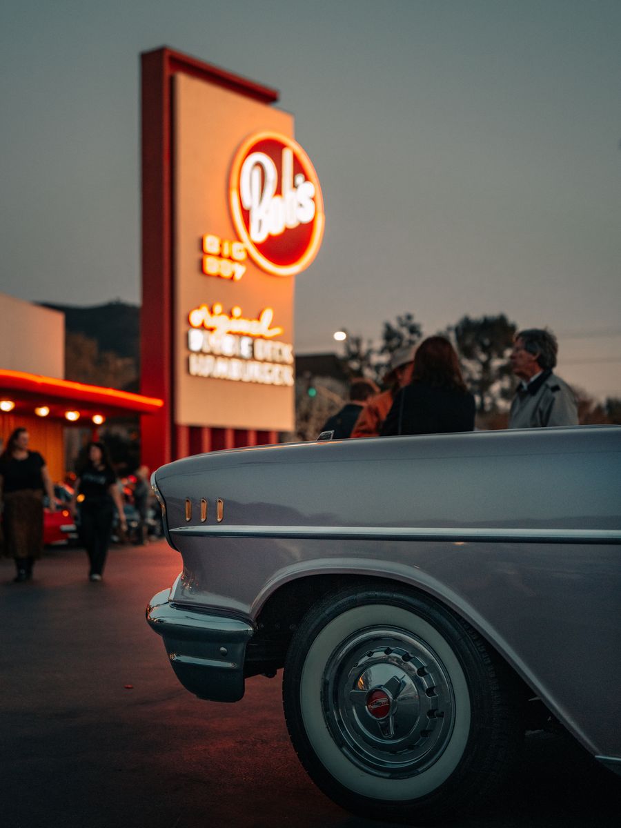 A vintage car at a neon-lit American diner