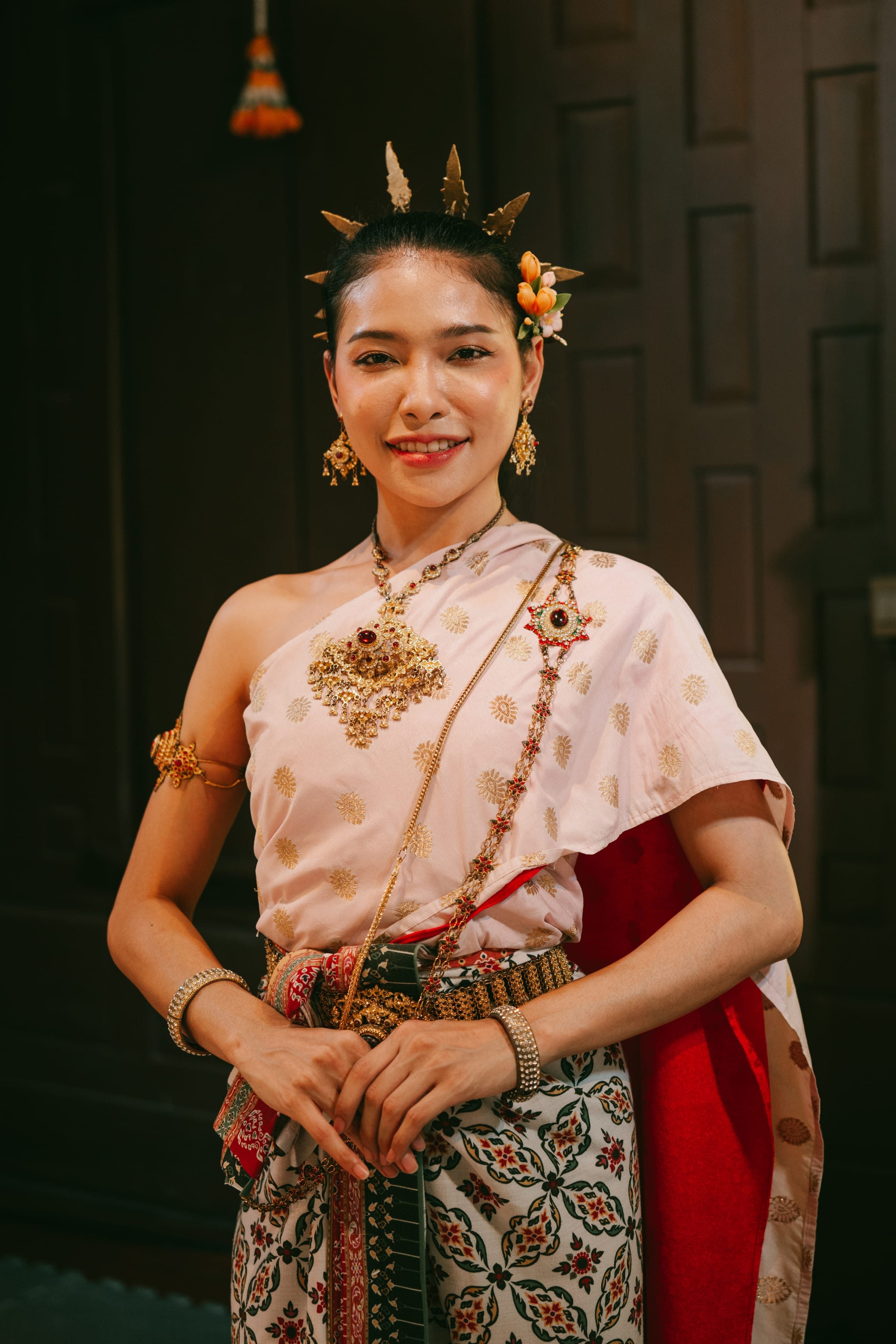 A young woman in traditional Thai dress with gold jewellery and a headdress.